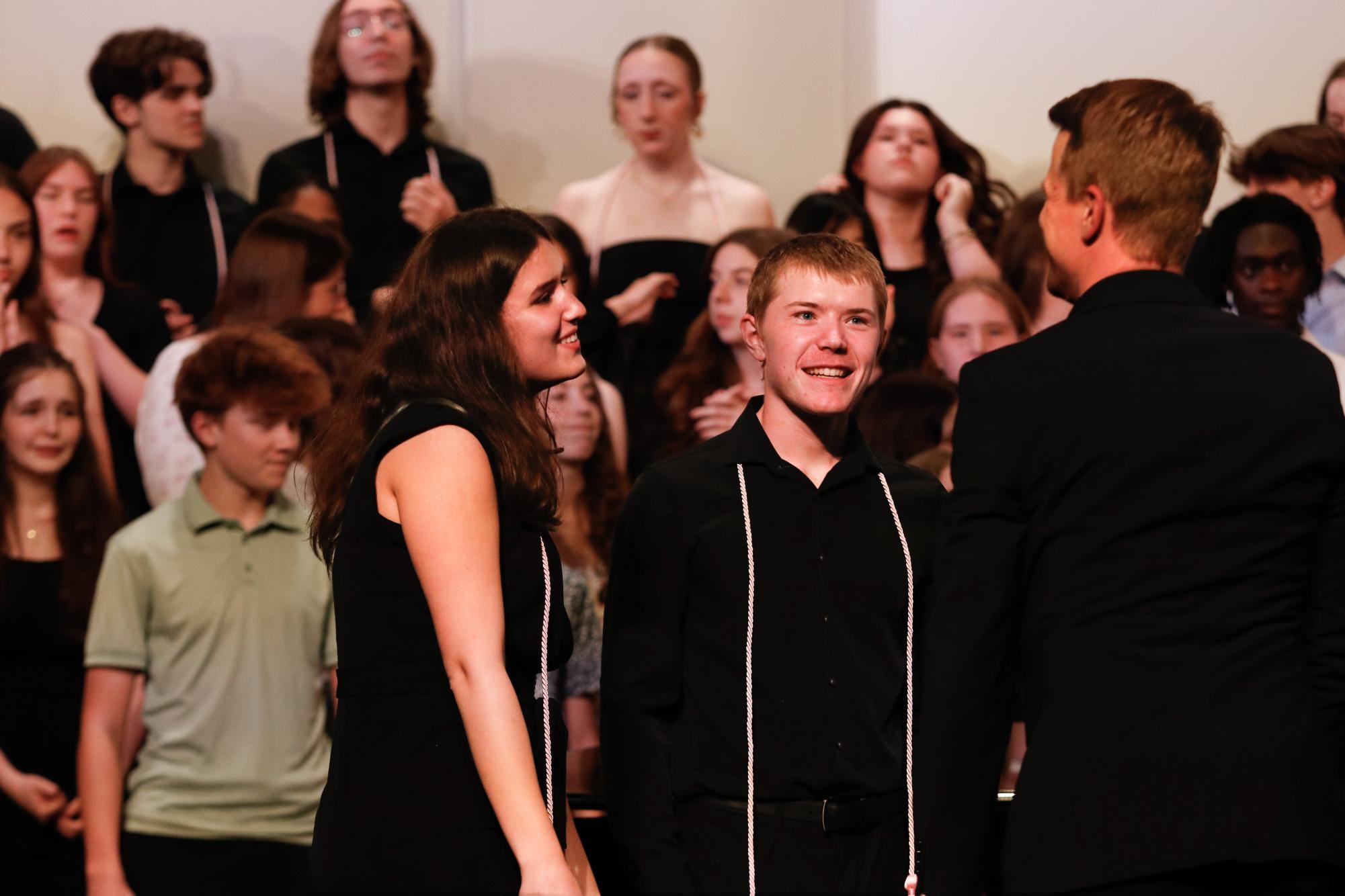 David Haas awards Eva Ortega Lopez '26 and Gabriel Conrad '26 with director's awards for West Singers at their final concert May 18. The last recognition occurred before groups combined for the alma mater.