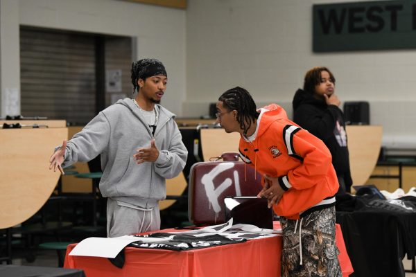 Describing his business, First Love Yourself, Anterrion Redd attempts to promote his street wear at the Black-Owned Business Fair on April 30.