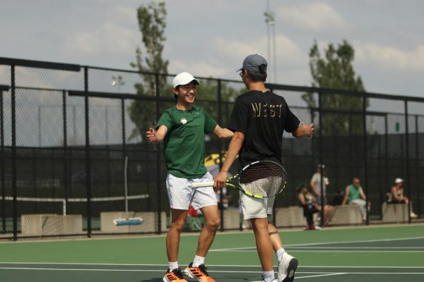 Aaron Kang ’27 and Jensen Lin ’27 high five after qualifying for State at the West High Tennis Courts May 16.

