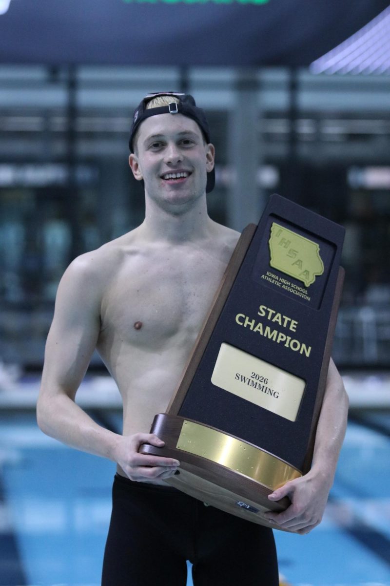 Smiling proudly, Oliver Mikulski '26 holds West's state champion trophy at the swim state championship meet Feb. 14. 